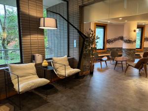 een lobby met stoelen en een tafel en ramen bij Sengokuhara Onsen Hotel in Hakone