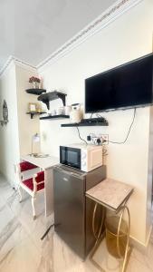 eine Küche mit einem Schreibtisch, einer Mikrowelle und einem TV in der Unterkunft House of Royalty in Walmer