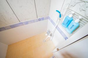 two bottles of water are sitting on a shelf in a bathroom at FamC in Nakafurano
