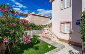a garden with pink flowers in front of a building at 2 Bedroom Awesome Apartment In Povljana in Povljana +21 photos