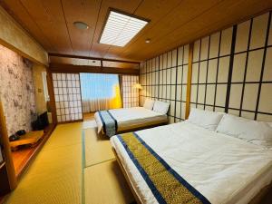 Een bed of bedden in een kamer bij Sengokuhara Onsen Hotel