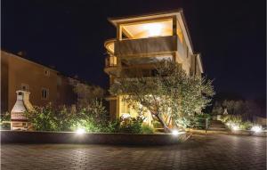 un edificio con un árbol delante de él por la noche en Lovely Apartment In Sveti Vid Miholjice, en Sveti Vid-Miholjice 23 fotos más