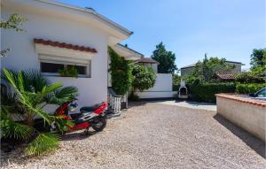 a scooter parked in front of a house at 2 Bedroom Amazing Apartment In Malinska in Malinska +18 photos