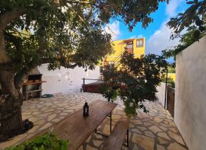 a bottle of wine sitting on a wooden bench under a tree at La Casita de Madera in El Paso
