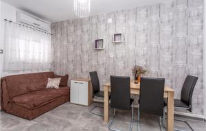 a living room with a couch and a table with chairs at 2 Bedroom Amazing Apartment In Malinska in Malinska