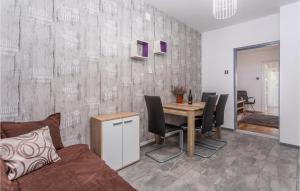 a living room with a table and chairs and a couch at 2 Bedroom Amazing Apartment In Malinska in Malinska