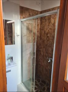 a shower with a glass door next to a sink at La Casita de Madera in El Paso +10 photos