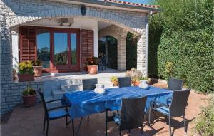 a blue table and chairs on a patio at Holiday Home Krse Cr in Premantura