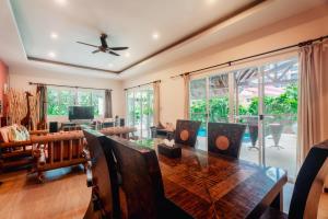 een eetkamer met een tafel en een plafondventilator bij Chaba Pool Villa in Nai Harn Beach