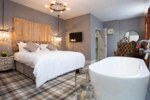 um quarto com uma cama grande e uma banheira em The King's Head em Beverley