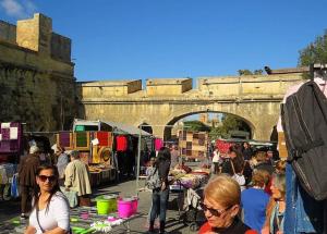 a crowd of people at an outdoor market under a bridge at Tranquil Three Cities Stay in Cospicua