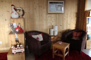ein Wohnzimmer mit 2 Stühlen und einem Tisch in der Unterkunft Les Alpages in Bonlieu