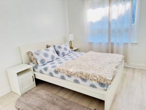 a white bedroom with a bed and a window at Amazing Home Near Toronto Airport with 2 Parking in Toronto