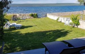 un cortile con tavolo e sedie accanto all'acqua di Amazing Apartment In Dobropoljana a Dobropoljana