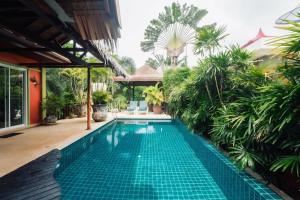 een zwembad in een huis met een tuin bij Chaba Pool Villa in Nai Harn Beach