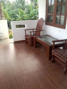 Habitación con mesa, sillas y banco en Ceylone Sun Garden, en Talpe