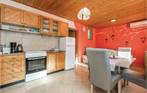 a kitchen with red walls and a table and chairs at 1 Bedroom Pet Friendly Home In Lovran in Lovran