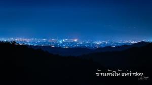 a view of a city from a mountain at night at บ้านต้นไม้แม่กำปอง Baan TONMAI MAEKAMPONG in Chiang Mai
