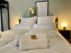 a white bed with towels on top of it at Cozy City Apartment im Zentrum in Nürnberg