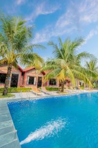 a resort with palm trees and a swimming pool at Tam Coc Green Garden Bungalow in Ninh Binh