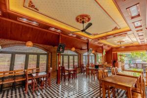 a restaurant with wooden tables and chairs and windows at Tam Coc Green Garden Bungalow in Ninh Binh