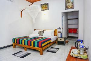 a bedroom with a bed with a colorful blanket at Sunrise Villa Pidurangala in Sigiriya