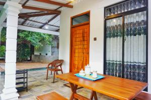 a dining room with a wooden table and chairs at Sunrise Villa Pidurangala in Sigiriya