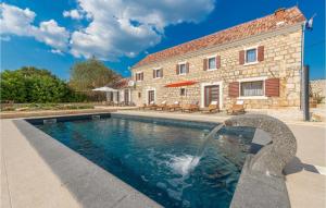 a swimming pool with a water fountain in front of a house at Four-Bedroom Holiday Home In Citluk in Čitluk