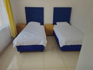 two beds in a small room withthritisthritislictslictslicts at Royal Inn - Fully Furnished Self-Catering Apartments in Lenasia