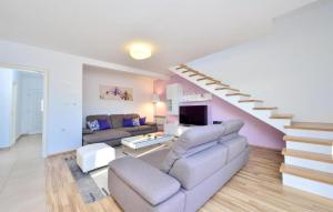 a living room with a couch and a staircase at Cozy Home In Unesic With Sauna in Unešić
