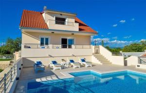 a villa with a swimming pool and a house at Cozy Home In Unesic With Sauna in Unešić +20 photos