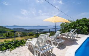 a group of chairs and an umbrella next to a pool at Stunning Home In Slano With Wifi in Slano
