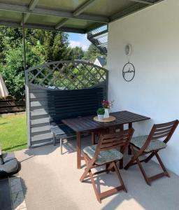 a patio with a wooden table and two chairs at Ferienwohnung König in Schnaittenbach