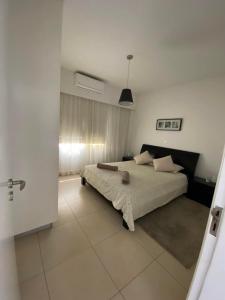una camera da letto con un letto grande in una stanza di Elysia park rose apartment a Paphos Altre 25 foto