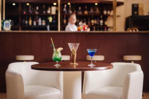 a table with three glasses on it in a bar at Rasstal Spa Hotel in Naberezhnyye Chelny