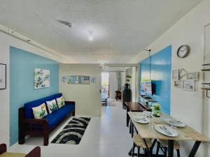 a living room with a blue couch and a table at Kembali CONDO Resort with Sea View in Davao City