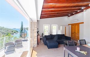 Una sala de estar con un sofá azul y un balcón. en Gorgeous Home In Vela Luka With Wifi, en Vela Luka