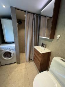a bathroom with a washing machine and a sink at Boende på Marholmen in Norrtälje