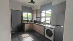 a kitchen with a washing machine and a washer at The Oasis Kuantan with Private Pool in Kuantan +9 photos