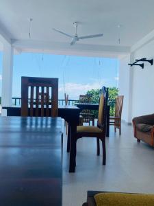 ein Esszimmer mit einem Tisch und Stühlen mit Aussicht in der Unterkunft Villa Serenity - Jayavikumgama in Weligama