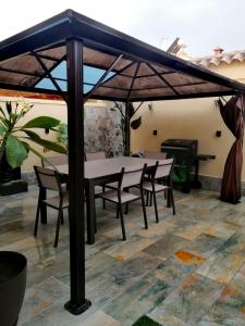 a table and chairs under an umbrella on a patio at Mikalita in San Fernando