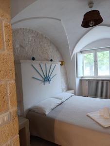 Un dormitorio con una cama con un reloj en la pared. en Trulli Abate Mauro, en Cisternino