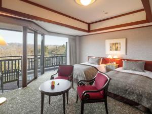 a hotel room with two beds and a balcony at Hakuba Tokyu Hotel in Hakuba