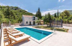a swimming pool with lounge chairs and a house at Amazing Home In Bijeli Vir in Bijeli Vir