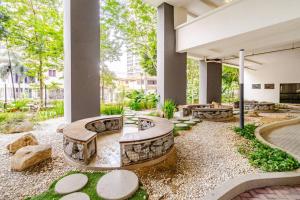 an outdoor patio with a firepit and benches and rocks at Arte Plus Jalan Ampang, KLCC Level 35 in Kuala Lumpur