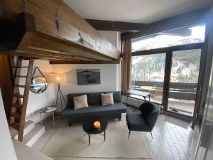 a living room with a couch and a loft bed at Les GRANDS SORBIERS à Méribel - Charmant studio situé à 2 pas des pistes & du centre de Méribel in Les Allues +1 photo