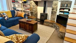 ランベリスにあるHouse in Llanberisの青いソファと暖炉のあるリビングルーム