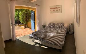 a bedroom with a bed and a door to a yard at Sous les pins parasols in Vidauban +35 photos