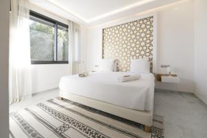 a white bedroom with a large bed and a window at DAR KAYIS & LAILA in Marrakesh +31 photos