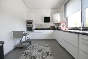 a white kitchen with a chair and a sink at DAR KAYIS & LAILA in Marrakesh
